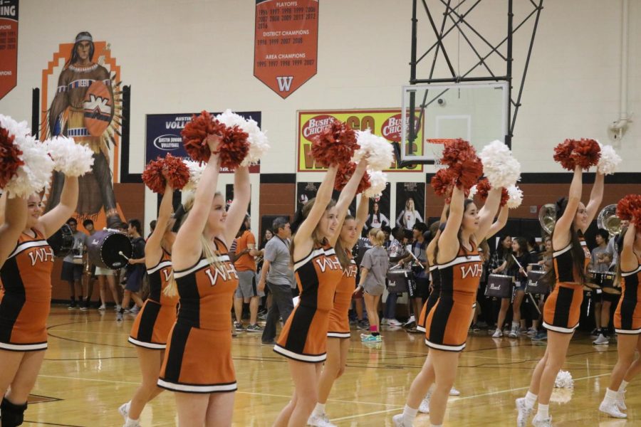 Varsity cheerleaders perform their routine for the students attending the pep rally. 
