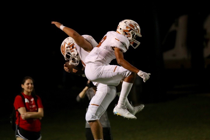 In celebration of scoring a touchdown, seniors Mario Debs and Mohan Hegde jump.