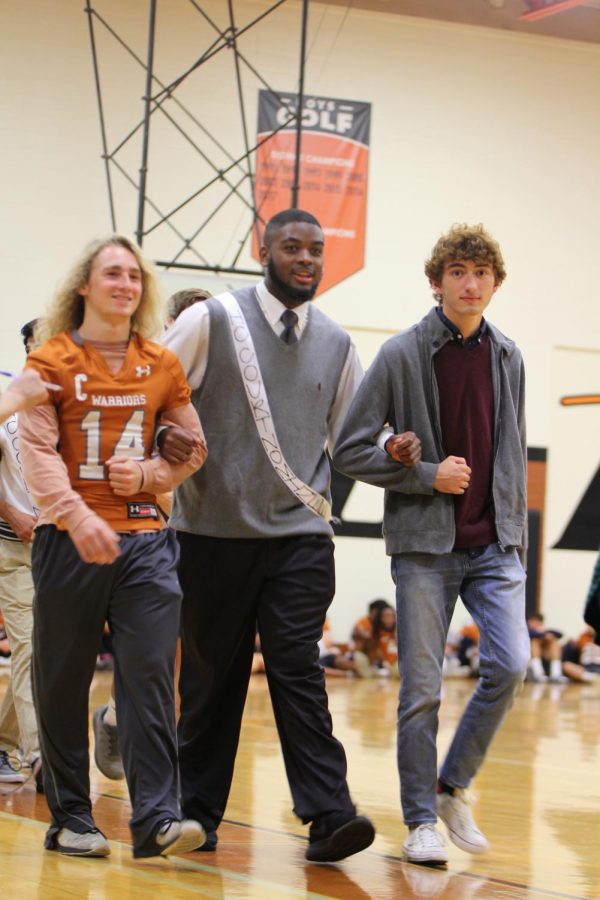 James Jarmon 19 is escorted by seniors Colton Roberts and Zach Hoover for the Homecoming court.