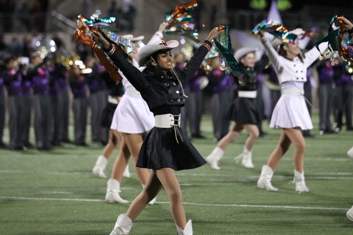 Nikita Karthik 20 poses with her arms up in a v-shape during the SunDancers halftime routine.