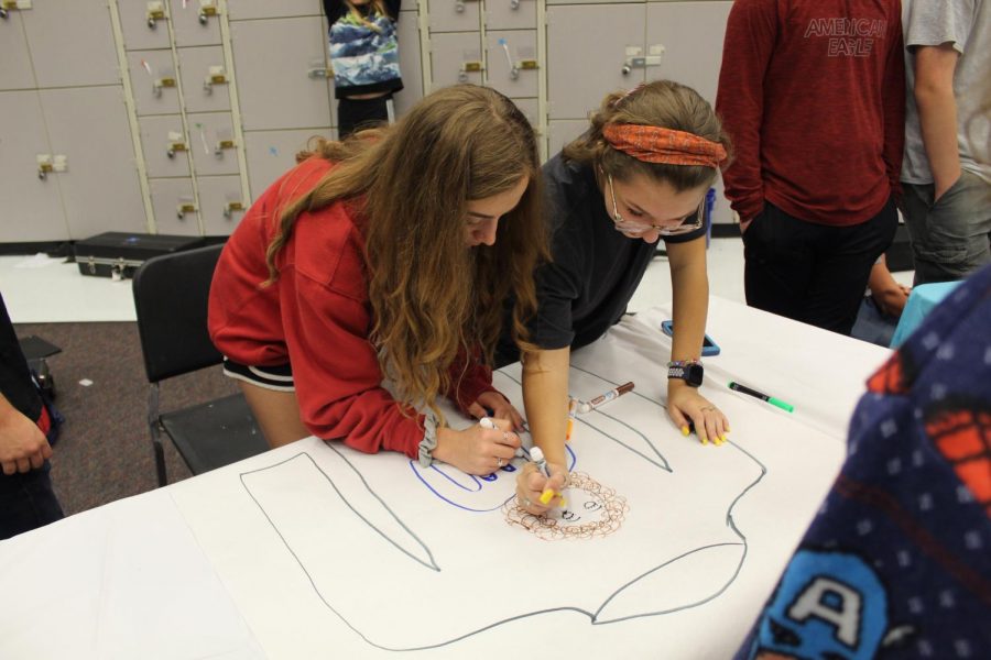 Sophomores Liz Brown and Carly Broome design their teams sweater.