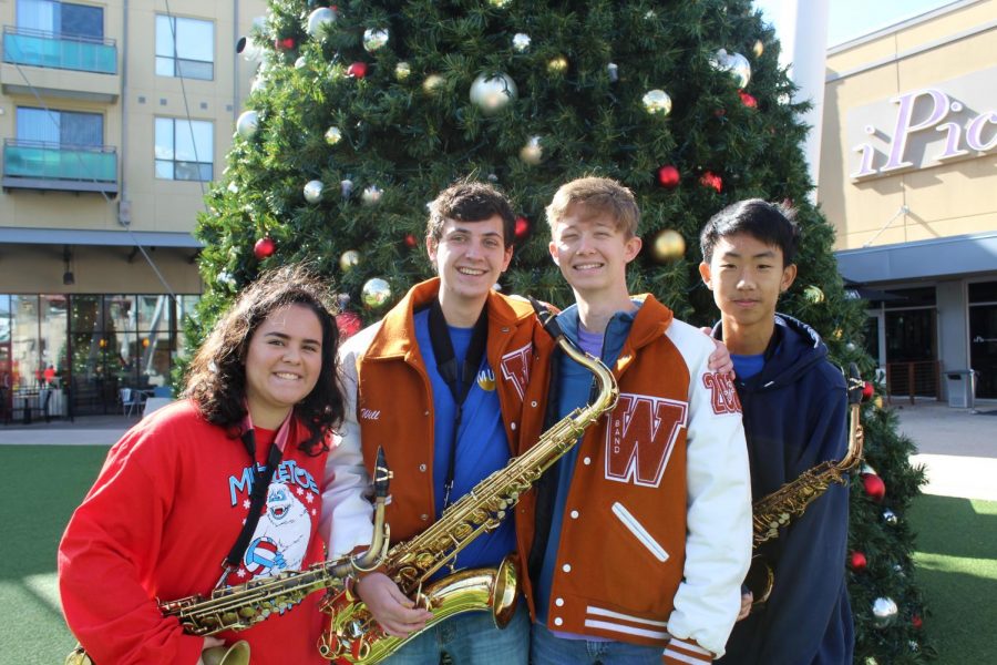 Madison Metzger 20, Will Sedberry 20, Andrew Stevens 20, and Victor Yu 21 stand in front of the Domains Christmas tree before their performance.
