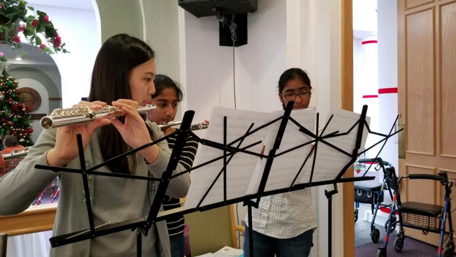 Elaine Chen 21, Sanjana Kumar 21, and Arti Madan 21 play a holiday piece on their flutes.