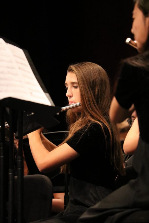 Alice Gaede 22 plays the flute while maintaining her posture.