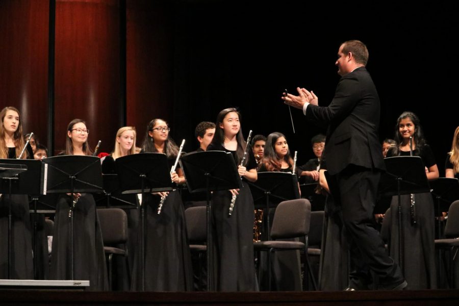 Director Brandon Winters applauds for the Westwood Symphonic band following their performance.