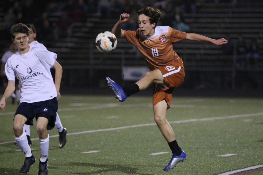 Max Wiele 21 jumps up to bring his foot to the ball.