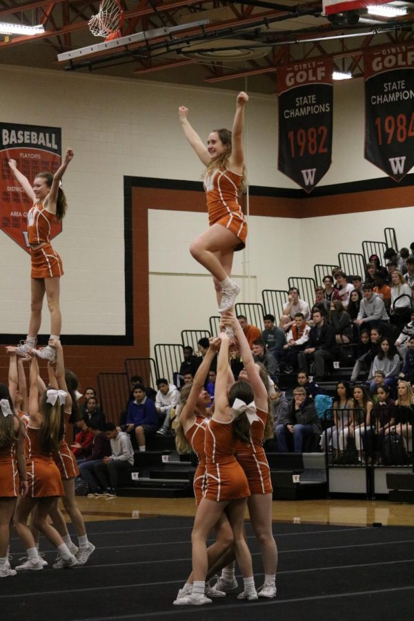 Sami Greisdorf 21 is hoisted up by the cheer team during their performance.