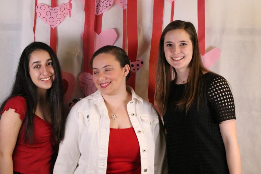 Students enjoy taking pictures at the heart-themed photo booth.