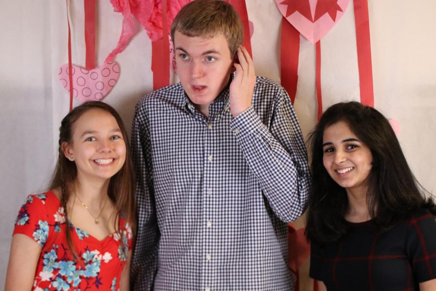 Students enjoy taking pictures at the heart-themed photo booth.