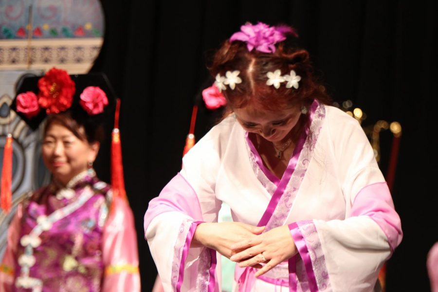 A performer bows down while representing a fashion era of China.