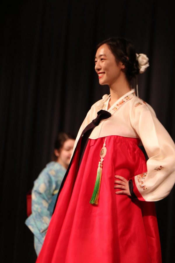 Janice Oh 19 smiles as she wears traditional Korean attire at the fashion show.