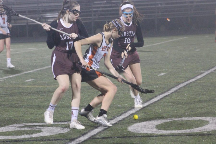 Bailey Trigg 20 blocks an opposing player while focusing towards the ground ball. 