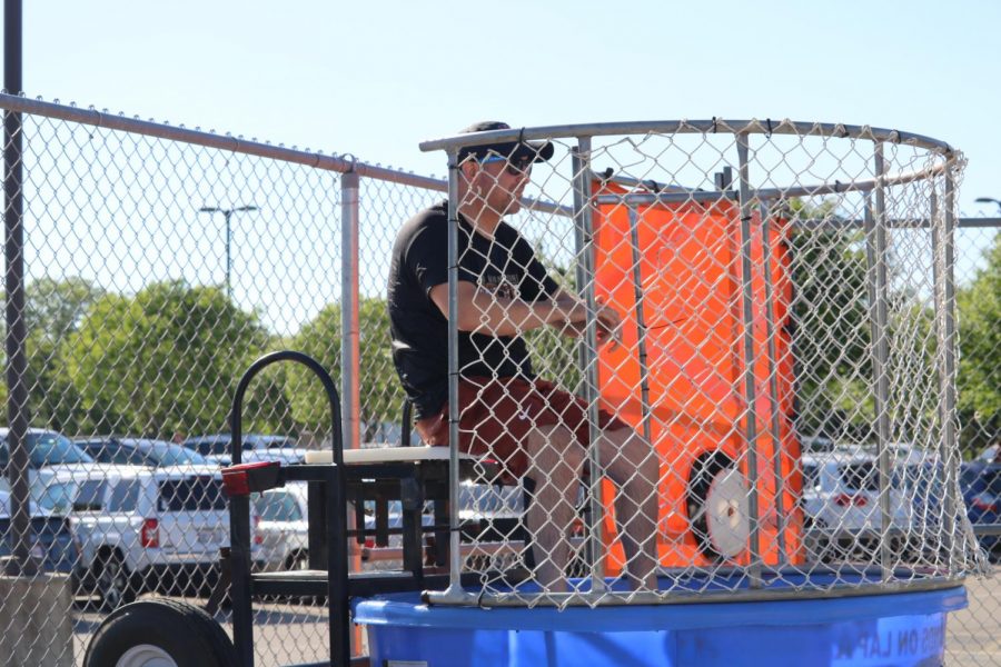 Principal Mario Acosta sits in the dunk tank as students attempt to dunk him. 