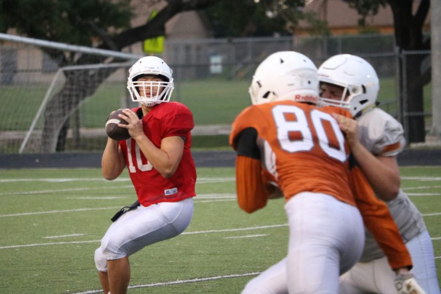 Robbie Jeng 21 looks down the field, searching for an open receiver while EJ Wiley 21 tries to reach him.