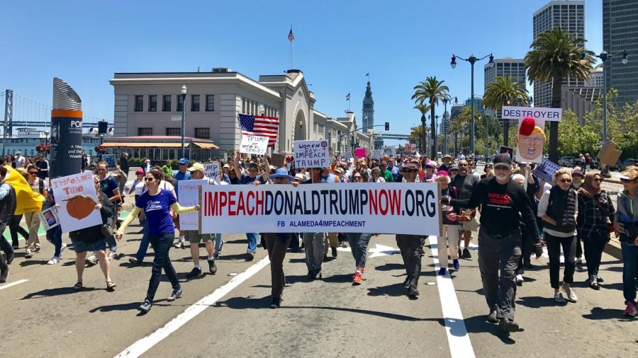 Protesters march while holding signs calling for Trump's impeachment on July 2, 2017.