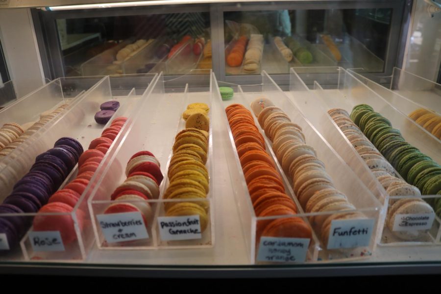 A unique variety of flavors of macarons are displayed at the front of the shop.
