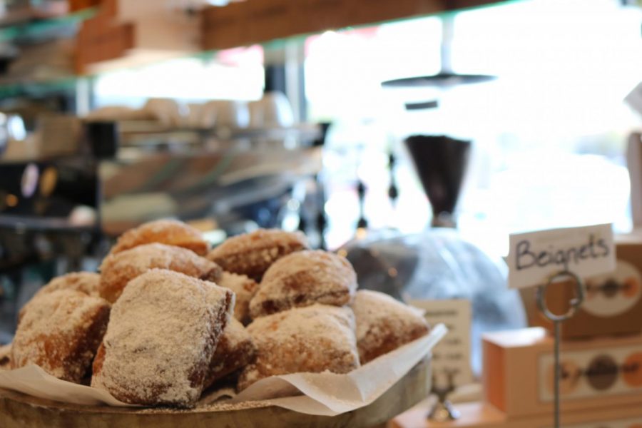 Fresh beignets are delicately displayed on a plate at the front of the shop.