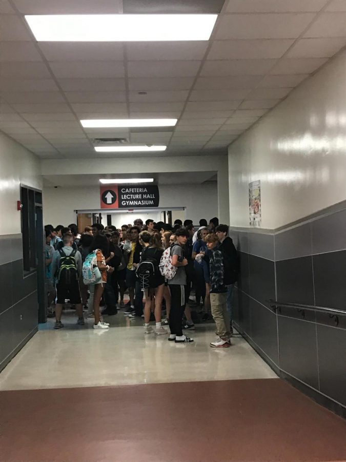 Students wait to pass through the hallway after part of the school was blocked off to allow EMS workers to do their job.