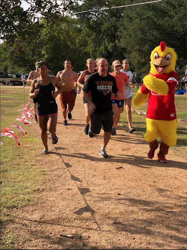 Principal Acosta races alongside students during the 1.5 mile run. The run was held on the Harper Park trails.