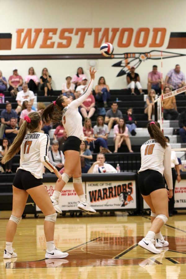 Abby Gregorczyk 21 hits the ball into the air while Audrey Quesnel 20 prepares to jump and hit it over the net. Through their teamwork, Gregorczyk and Quesnel score a point.