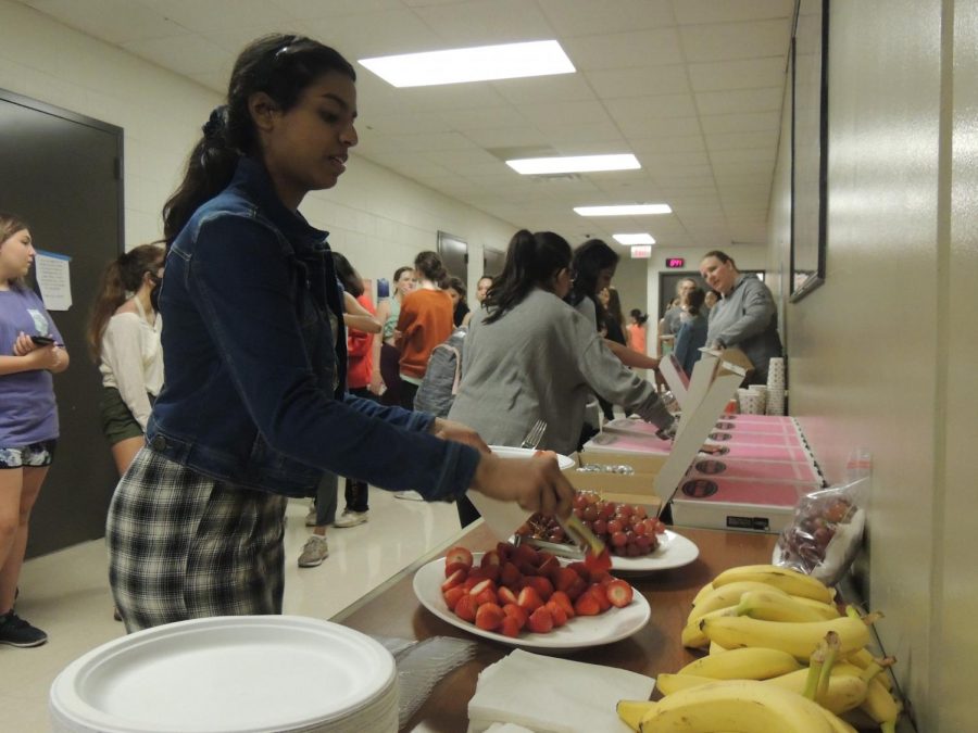 Srishti Kannan 21 picks up strawberries to eat with her breakfast. This is her second year of being a member of Warrior Pride. Im really thankful for the moms that made this breakfast happen because after the rehearsal I felt lightheaded, but [after eating] I felt a lot better, Kannan said.
