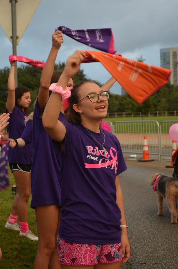 Claire Pitre 21 stands at the sidelines and cheers for the participants. Pitre has been attending Race for the Cure for three years. Everyone that goes to support is happy to be there and happy to be supported, Pitre said. Its a really inspiring and beautiful thing to see. 