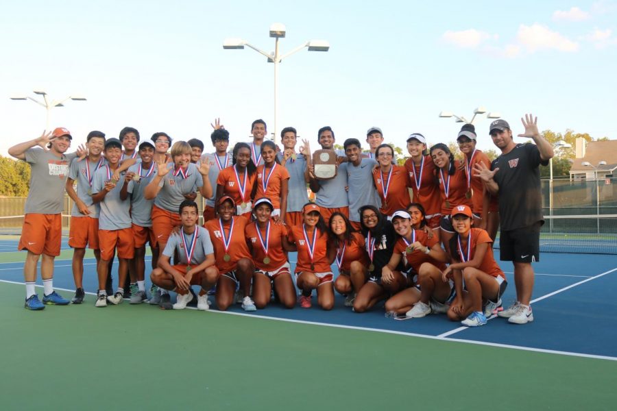 The varsity tennis team poses for a picture, celebrating their tenth straight district title win. In the championship, they dominated Vandegrift for an 11-0 victory.