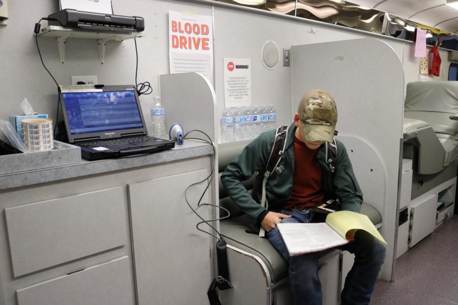 Jayden Wiener 20 reads information about blood donation as he prepares for his turn.
