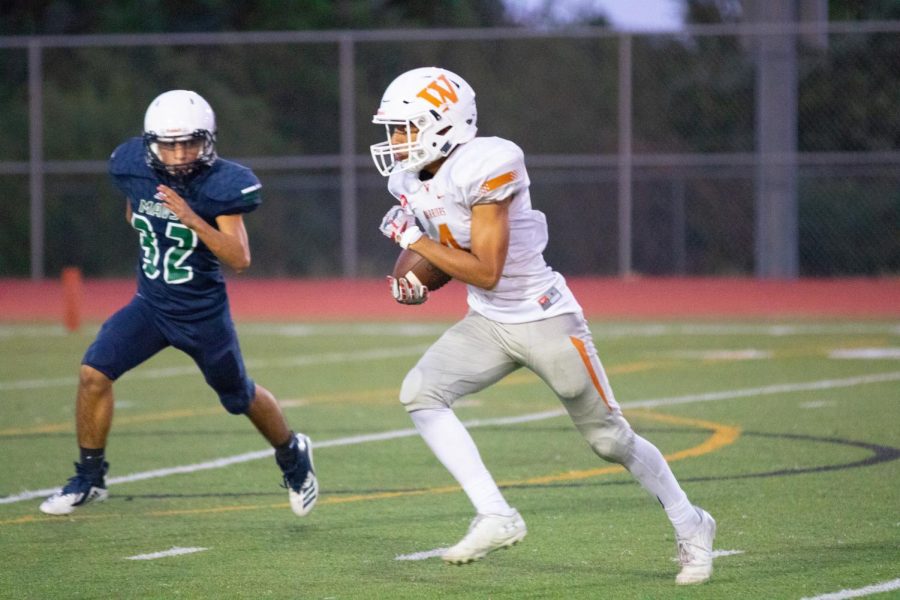 Holding the ball, Rayan Momin '22 sprints down the field. He ended the play by scoring a touchdown.