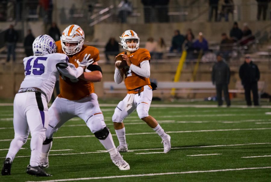 RJ Martinez 21 looks to make a pass as he searches for a hole in  the coverage. Martinez would ultimately tuck the ball and scramble on the play.