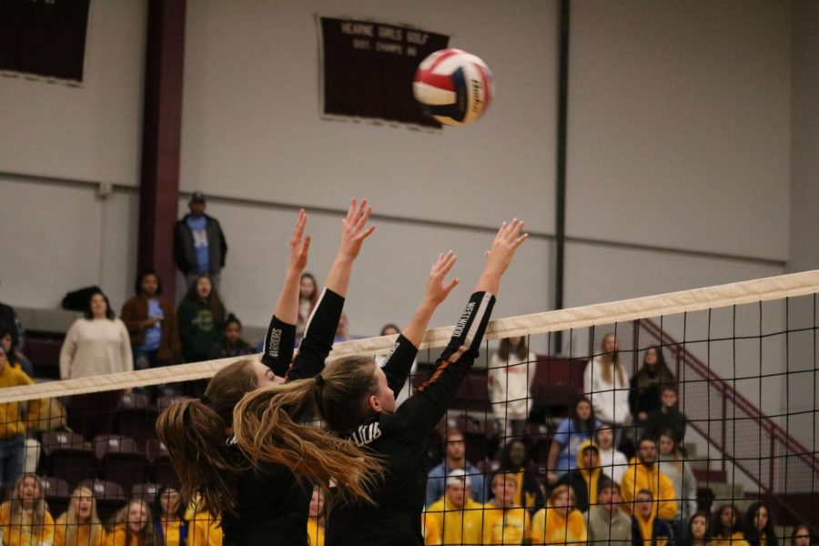McKayla Ross 22 and Kenzie Beckham 21 attempt to block the opponents middle blocker. The long rally ended in the Warriors favor as they won the point. 