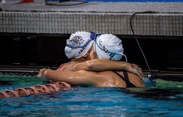 KyAnh Truong '21 hugs an opposing swimmer after a race last season. Truong announced she will continue her swimming career at Duke University in Durham, North Carolina.