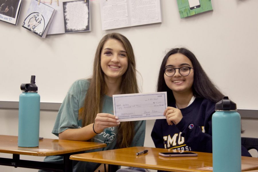 Alice Gaede 22 and Anushka Mazumdar 22 hold up the check that one of their sharks gave them to invest in their product. Their product was a pill bottle for opioids that help prevent overdoses.