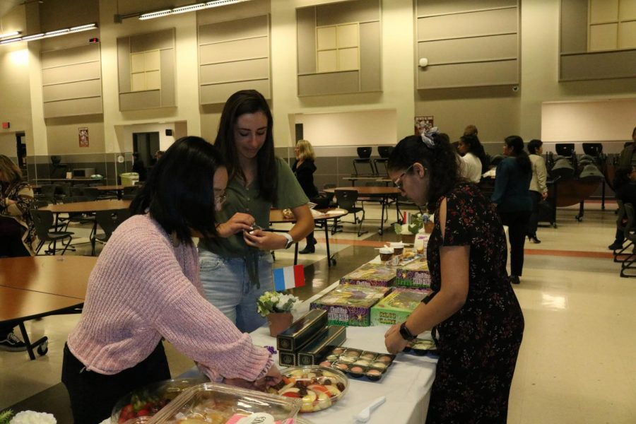 Junior NFHS members Asteria Tran, Azra Pleuthner, and Srilekha Cherukuvada volunteered to help set up food for the ceremony. They arrived one hour before the ceremony began to start setting up.