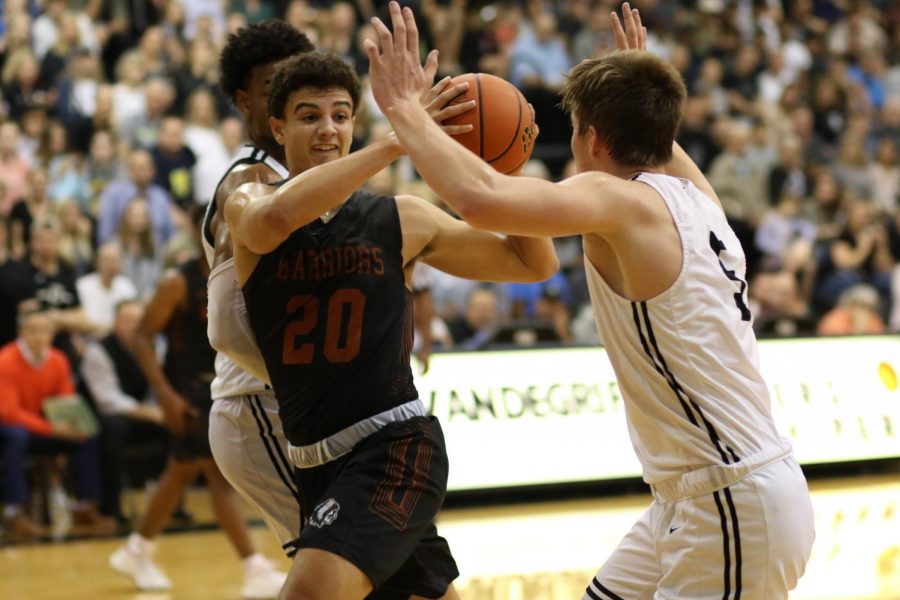 Sandwiched in between two defenders, Christian Robinson '20 attempts to pass the ball. This was during the first quarter and the energy was high.