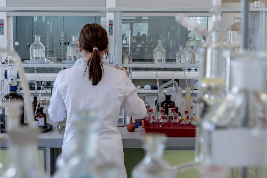 A woman in a lab coat analyzes samples in a laboratory.