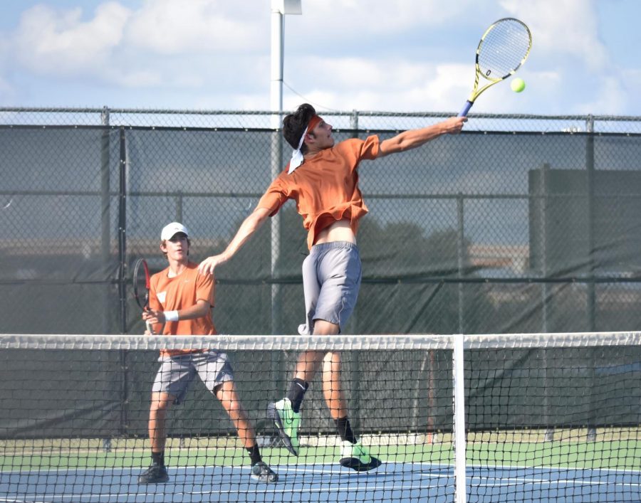 Leaping to poach the ball at the net, Nicolas Pesoli 21 extends with a backhand volley to put away the ball. This season marks the first year that Pesoli has played for a high school tennis program. 