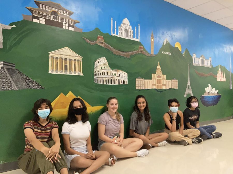 Simoni Khare ‘22, Arunima Das ‘23, Rosie Deal ‘22, Rhea Mucherla ‘21, Anya Gupta ‘23, and Nashitha Azeez ‘22 sit in front of the completed mural. They met the day before school started to take final pictures of the mural. Photo courtesy of Arunima Das ‘23.