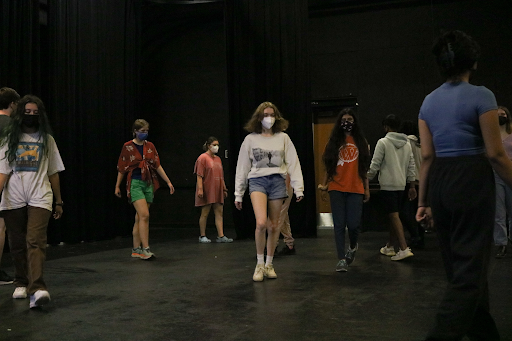 Students practice showing emotion through their movements in the theatre room. Ms. Lydia Coats, theatre director, gives directions about different emotions and movements to portray as students walk around the room trying them out. 