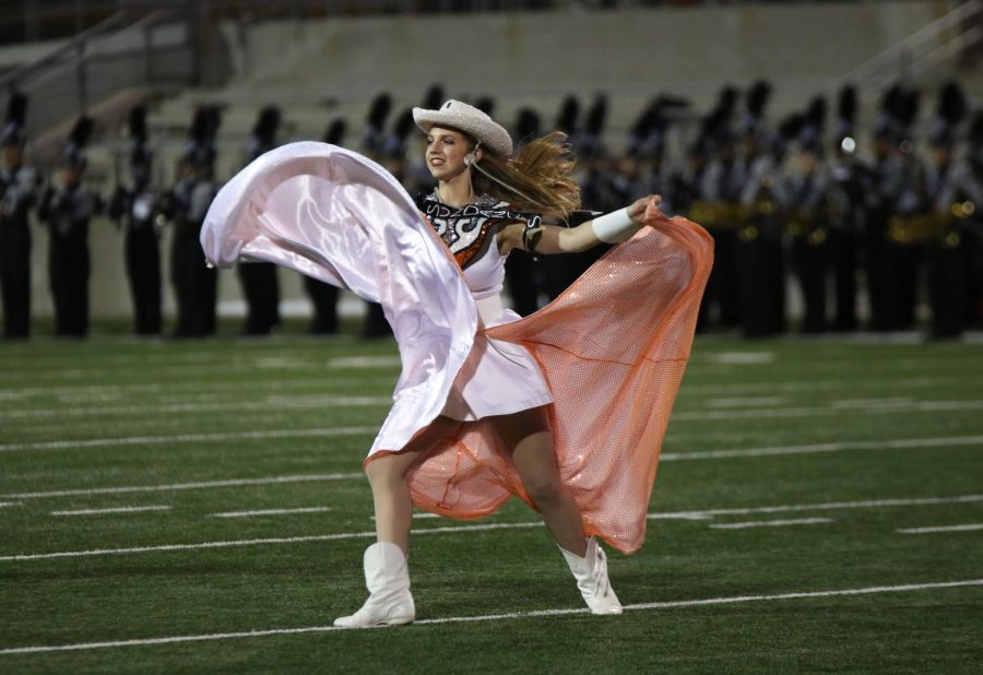 Holding her skirt, Bella Friedrich 22 performs at half time before the court is presented. The SunDancers were wearing their traditional hoco outfits for the performance.