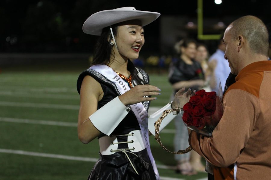 Talking with Dr. Mario Acosta, Catherine Zhang 22 receives the Homecoming queen crown. Zhang is also a member of the Westwood SunDancers.