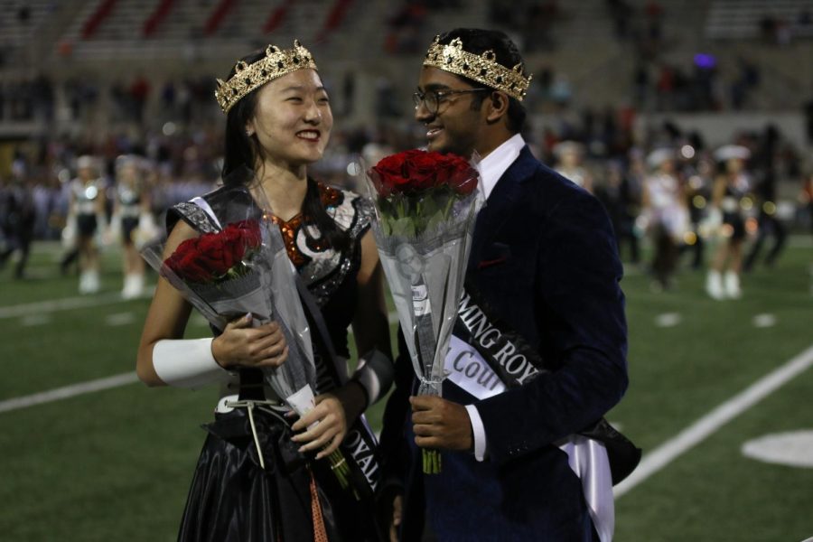 Smiling, Catherine Zhang 22 and Hrushi Saranu 22 pose for a picture after getting crowned Homecoming king and queen. The two also posed with Dr. Mario Acosta after this.