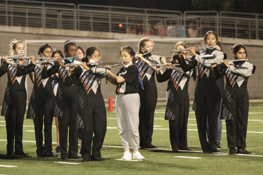 The flute section lines up to perform during the halftime show of the varsity football game. The band played Land of a Thousand Dances, a tradition for eighth grade night.