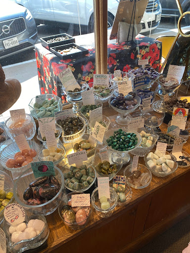 Numerous bowls of tumbled crystals line the window near the entry of The Crystal Works.
