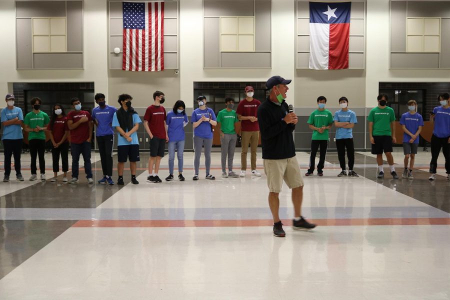 Standing in a circle, IB students listen intently to an instructor from Newks. After the instructions, the students split up to join their houses in other team building exercises.