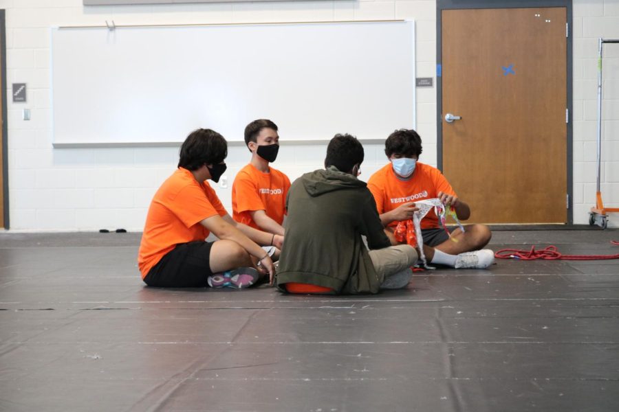 IB students from the House Caring sit in a circle blindfolding themselves. The students then proceeded to build a house out of ropes with no vision, encouraging trust and communication between house members.
