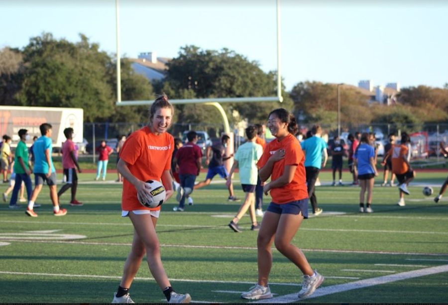 Laughing along the sidelines, Alice Gaede 22 and Anita You 22 play soccer together. Apart from soccer, IB students could participate in other outdoor games, including Capture the Flag in the Warrior Bowl. Students were allowed to choose their own teams. 