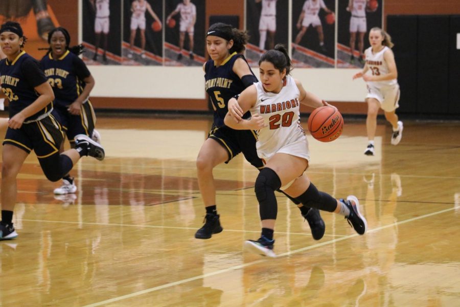 Speeding past her opponent, Bailee Dainton '25 holds the ball in her palm ready dribble her way towards making a basket. 