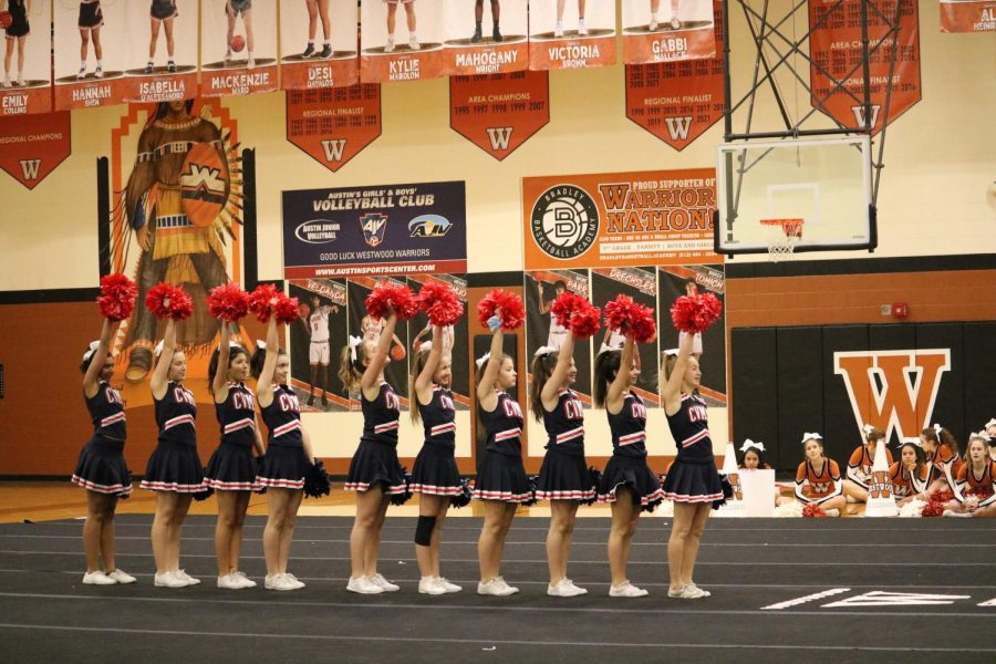 Holding their red pompoms in the air, the Canyon Vista Cheerleaders smile out to the audience. They thought of their performance as being a great success. 