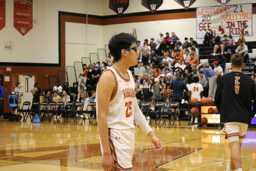 Youngchan Kang 22 participates in his first team warmup before the game starts.  Kang swiftly transitioned into free-throw practice with the rest of the team.